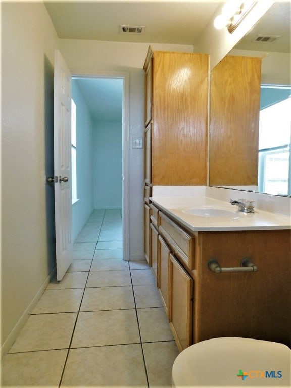 bathroom with toilet, vanity, and tile patterned floors