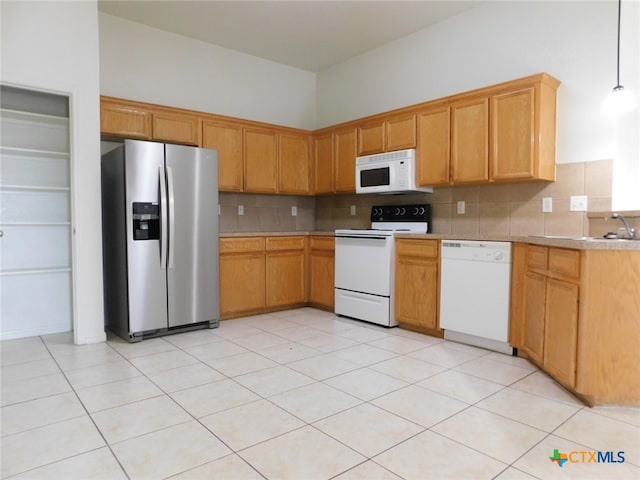 kitchen featuring tasteful backsplash, white appliances, light tile patterned flooring, and hanging light fixtures