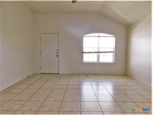 unfurnished room featuring light tile patterned flooring and lofted ceiling