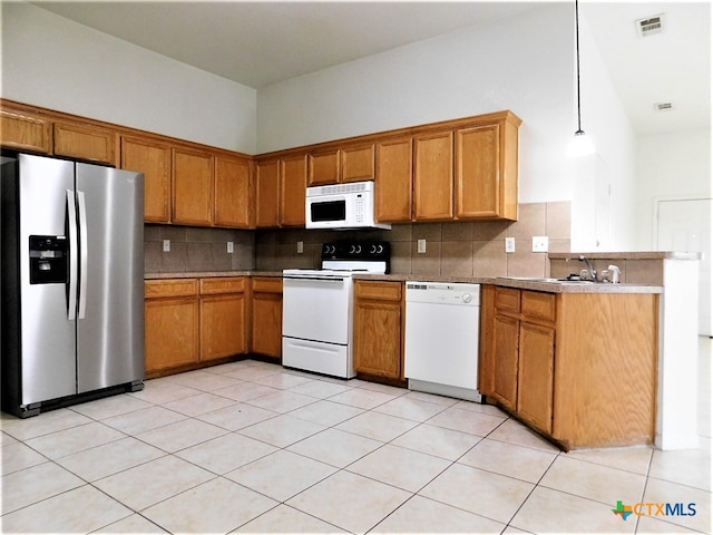 kitchen featuring backsplash, white appliances, light tile patterned floors, and decorative light fixtures