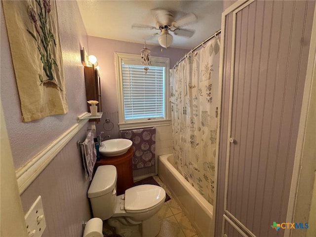 full bath featuring a sink, ceiling fan, toilet, tile patterned flooring, and shower / bath combo with shower curtain