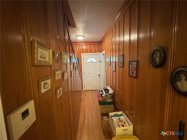 entryway featuring wood walls and a textured ceiling