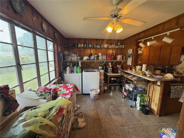 kitchen featuring washing machine and dryer, wooden walls, a textured ceiling, and ceiling fan