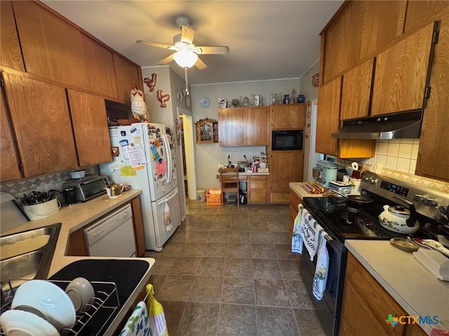 kitchen with light countertops, decorative backsplash, under cabinet range hood, and white appliances