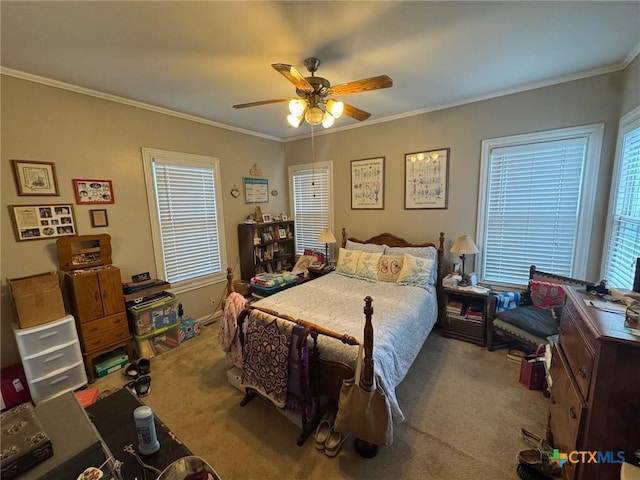 carpeted bedroom with ceiling fan and ornamental molding