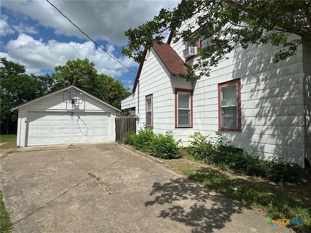 view of property exterior with an outbuilding, cooling unit, and a garage