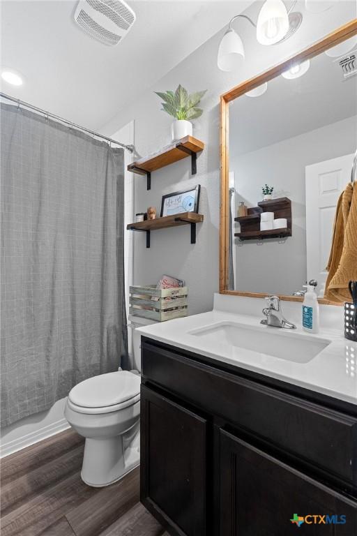 2512 Corradino St, Harker Heights, TX 76548 - bathroom with toilet, wood finished floors, vanity, and shower / tub combo with curtain