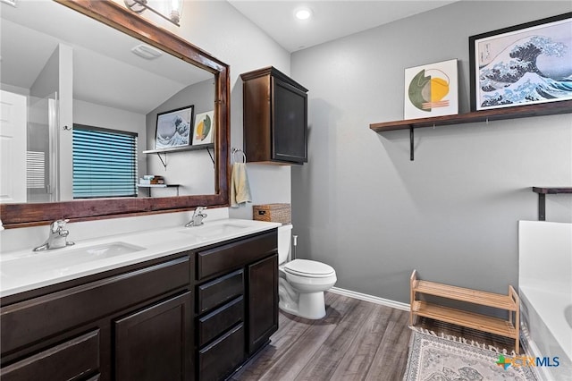 2512 Corradino St, Harker Heights, TX 76548 - bathroom featuring wood finished floors, toilet, a bath, double vanity, and baseboards