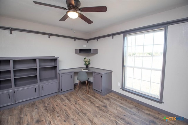 unfurnished office featuring ceiling fan and dark hardwood / wood-style floors