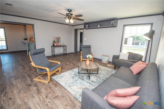 living room featuring ceiling fan, dark hardwood / wood-style floors, and crown molding