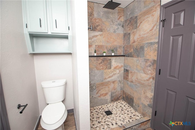 bathroom with toilet and tiled shower