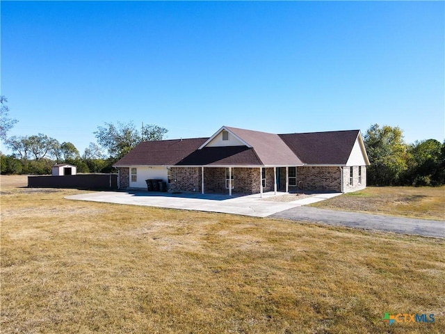 single story home with a front lawn and a patio area