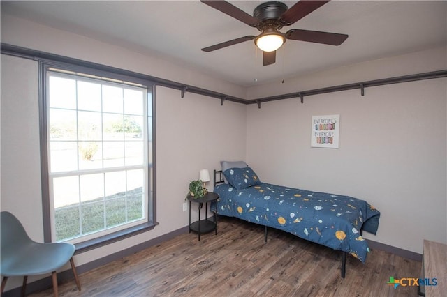 bedroom with ceiling fan, multiple windows, and hardwood / wood-style floors