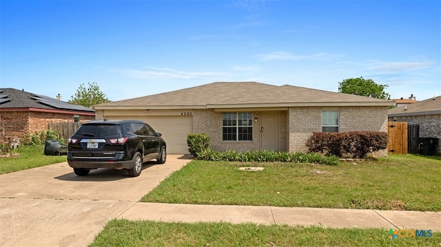 single story home with brick siding, a front lawn, concrete driveway, and a garage