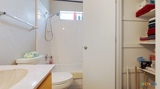 full bath with washtub / shower combination, a textured wall, toilet, and vanity