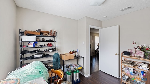 interior space with baseboards, visible vents, a textured ceiling, and dark wood-style floors