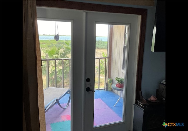 doorway to outside featuring a wealth of natural light, a water view, and french doors