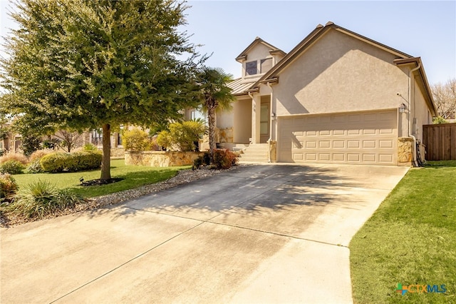 view of front facade featuring stucco siding, driveway, an attached garage, and a front yard