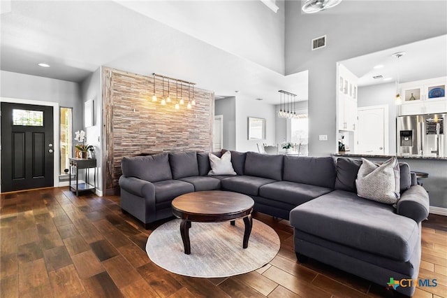 living area with visible vents, dark wood-type flooring, recessed lighting, a high ceiling, and baseboards