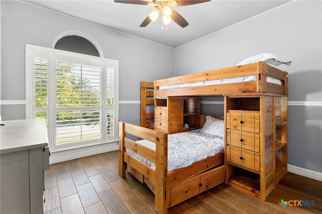 bedroom featuring baseboards, a ceiling fan, and wood finished floors