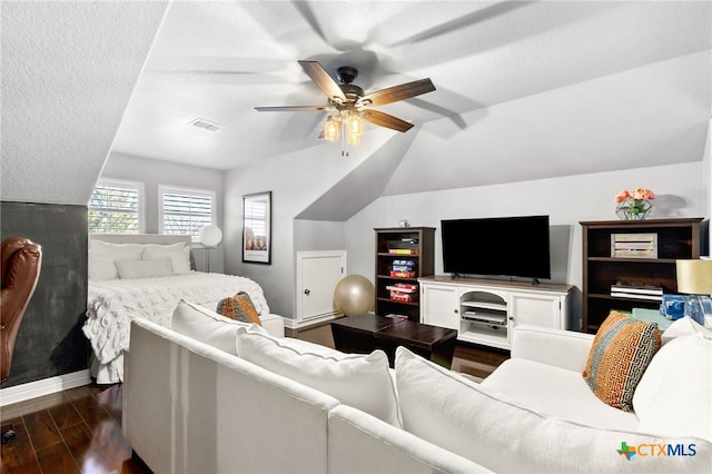 living room with visible vents, dark wood-type flooring, lofted ceiling, baseboards, and ceiling fan