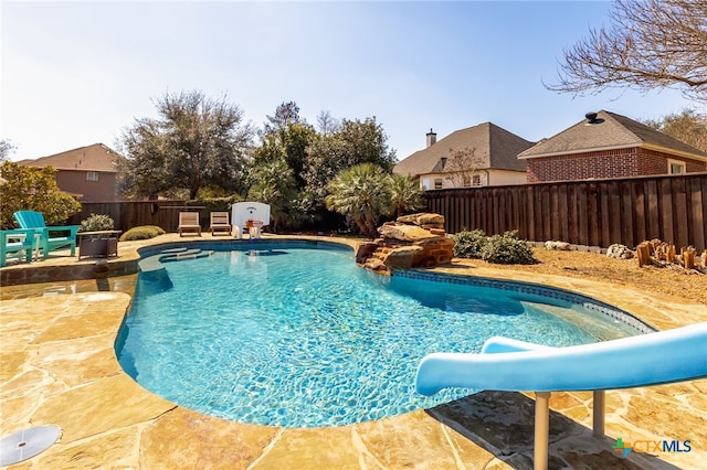 view of pool with a patio, a fenced backyard, a fenced in pool, and a water slide