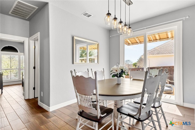 dining space featuring visible vents, plenty of natural light, and wood finished floors