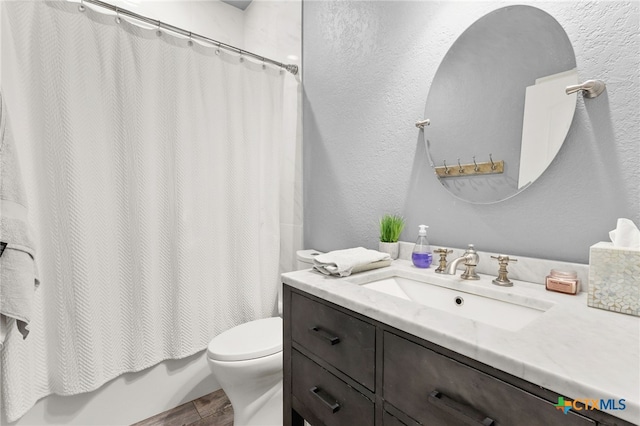 full bathroom featuring vanity, shower / bathtub combination with curtain, toilet, and a textured wall