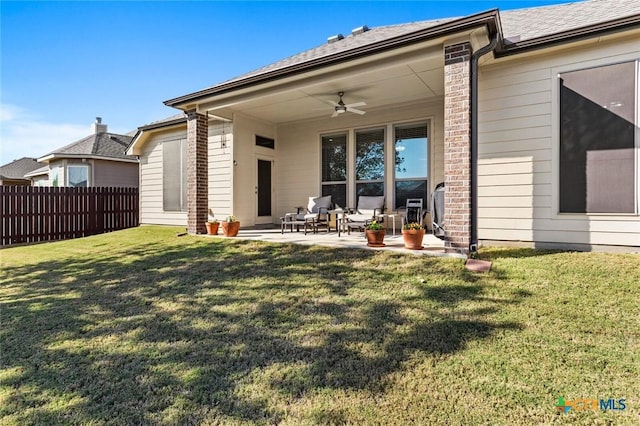 rear view of property with a lawn, ceiling fan, and a patio area