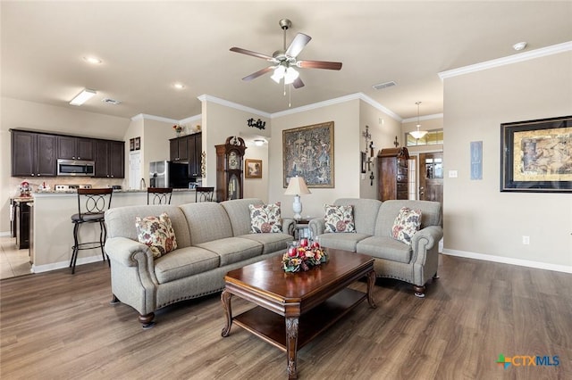 living room featuring dark hardwood / wood-style flooring, ceiling fan, and crown molding