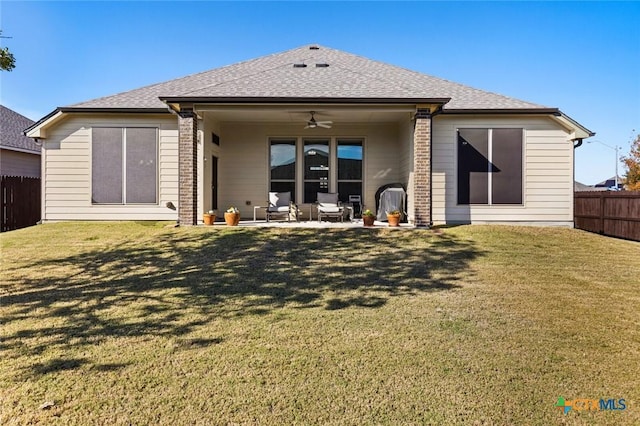 rear view of property featuring a lawn, ceiling fan, and a patio