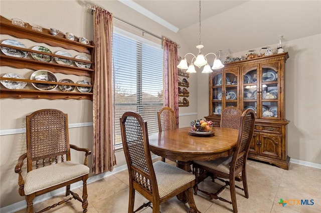 dining space featuring a notable chandelier, lofted ceiling, and light tile patterned floors