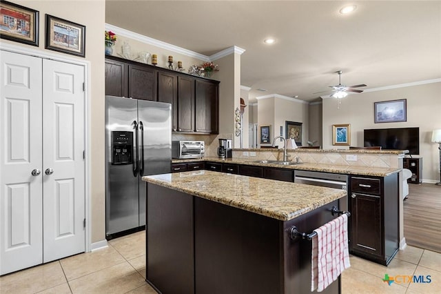 kitchen featuring sink, stainless steel refrigerator with ice dispenser, kitchen peninsula, dark brown cabinets, and a kitchen island