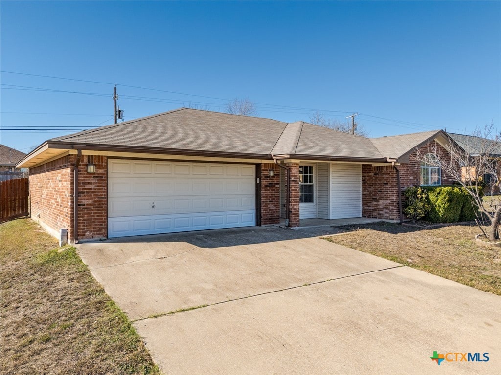 ranch-style home featuring a garage and a front lawn