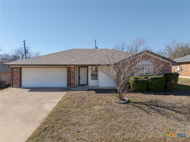 ranch-style home with a front lawn, central AC unit, and a garage