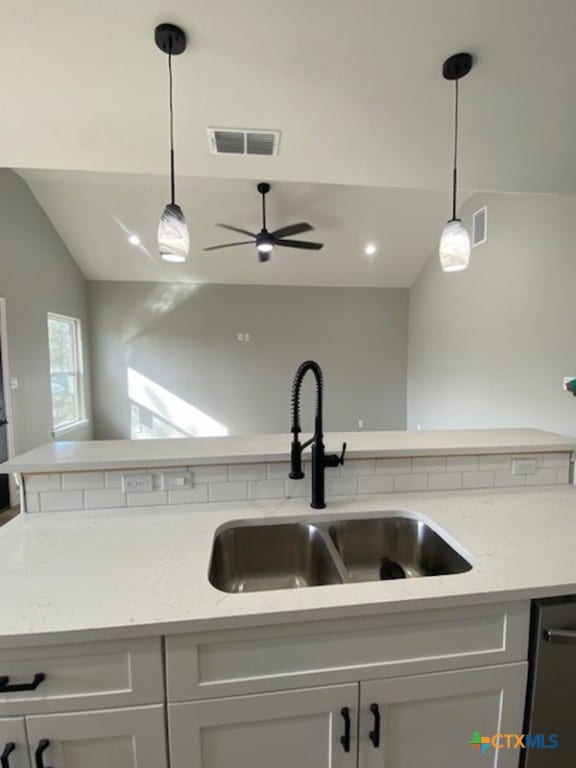 kitchen with decorative light fixtures, visible vents, and a sink