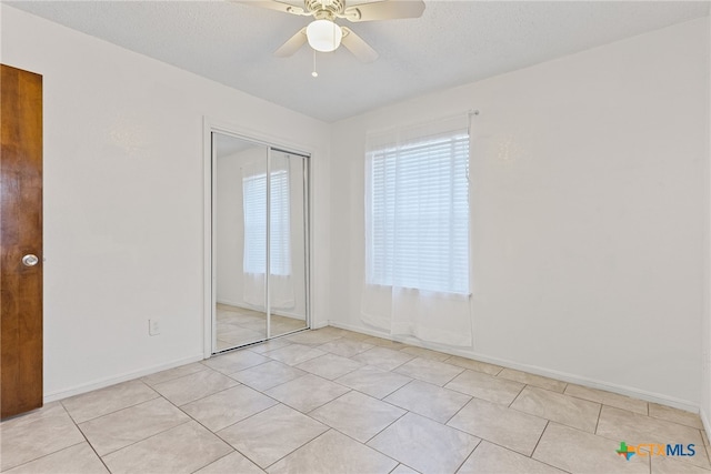 2013 Moonlight Dr, Killeen, TX 76543 - unfurnished bedroom with ceiling fan, a textured ceiling, a closet, and light tile patterned floors