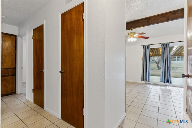 2013 Moonlight Dr, Killeen, TX 76543 - hall featuring light tile patterned floors, beam ceiling, and a textured ceiling