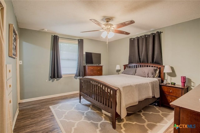 bedroom featuring a ceiling fan, baseboards, and wood finished floors