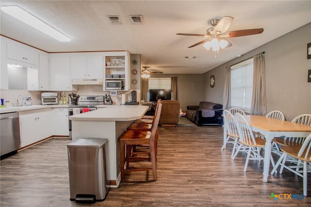 kitchen featuring visible vents, ceiling fan, white cabinetry, under cabinet range hood, and appliances with stainless steel finishes