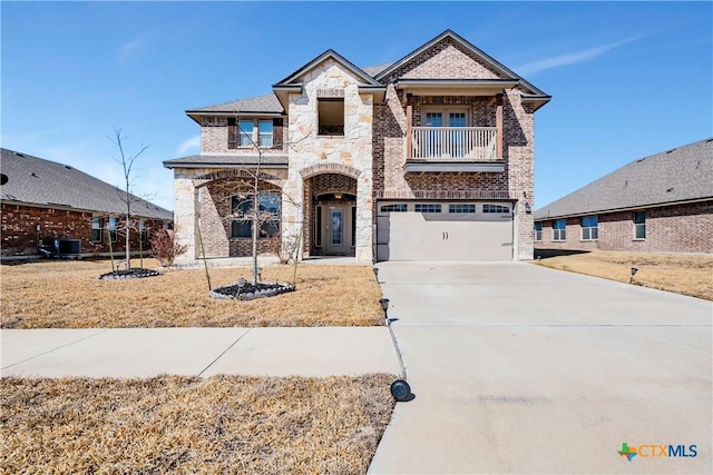 view of front of property featuring brick siding, concrete driveway, central AC, a balcony, and stone siding