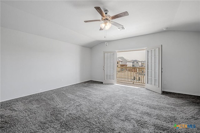 carpeted empty room with visible vents, baseboards, ceiling fan, and vaulted ceiling