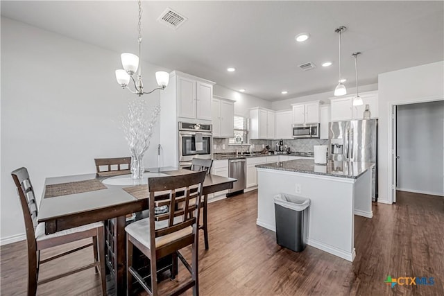 kitchen with visible vents, stainless steel appliances, and dark wood-style flooring