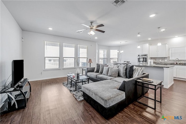 living area with recessed lighting, dark wood-style floors, and visible vents