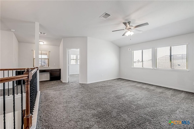 carpeted empty room featuring visible vents, baseboards, ceiling fan, and vaulted ceiling