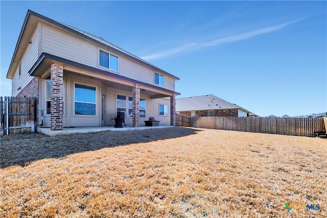 rear view of property featuring a patio and a fenced backyard