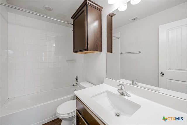 bathroom with bathtub / shower combination, toilet, vanity, and visible vents