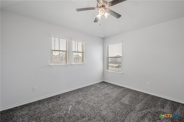 carpeted spare room featuring baseboards and ceiling fan