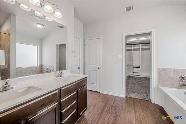 full bathroom featuring a bath, visible vents, and a sink