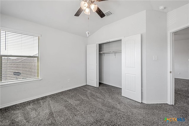 unfurnished bedroom featuring baseboards, visible vents, vaulted ceiling, a closet, and carpet flooring